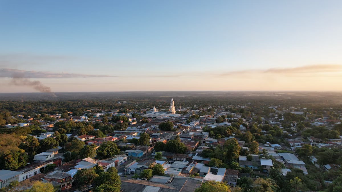Scenic aerial view of Zacatecoluca in El Salvador during a beautiful summer sunset with lush greenery and distant smoke.